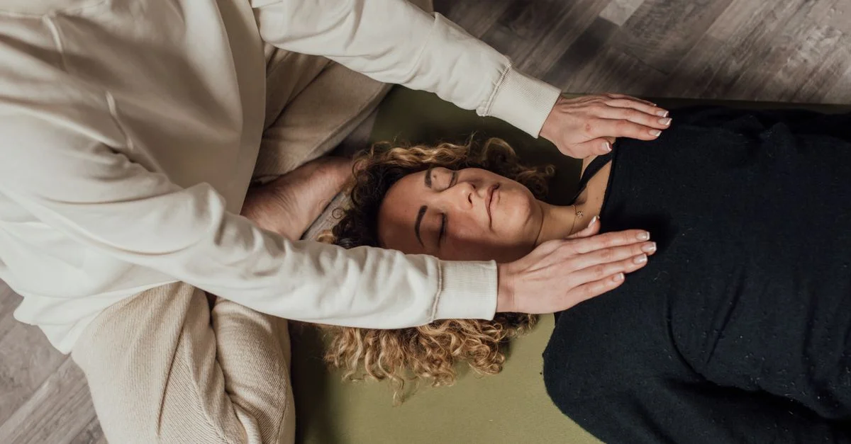 Une femme recevant une séance de guérison holistique à l'intérieur, axée sur la relaxation et le bien-être spirituel.