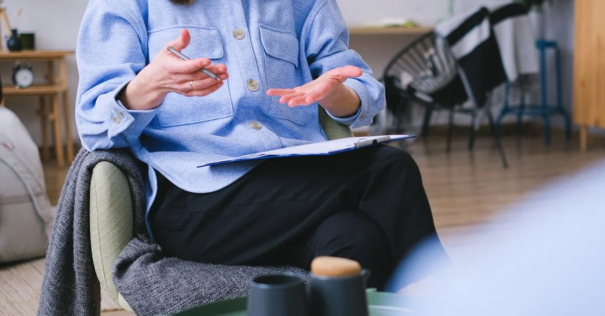 Un thérapeute consulte un client dans un bureau contemporain, axé sur la santé mentale.