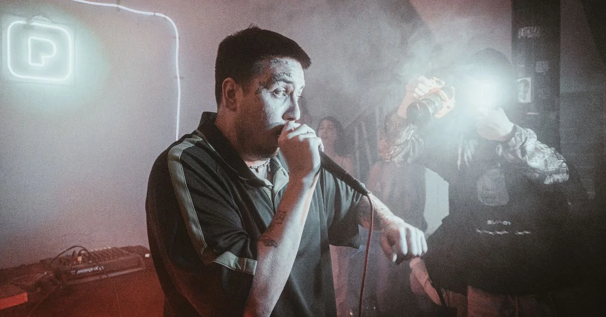 Musicien énergique se produisant live sur scène dans un club avec une ambiance vibrante et un engagement du public.