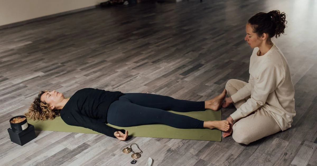 Deux femmes pratiquent la méditation et la relaxation à l'intérieur, se concentrant sur le bien-être et la paix intérieure.