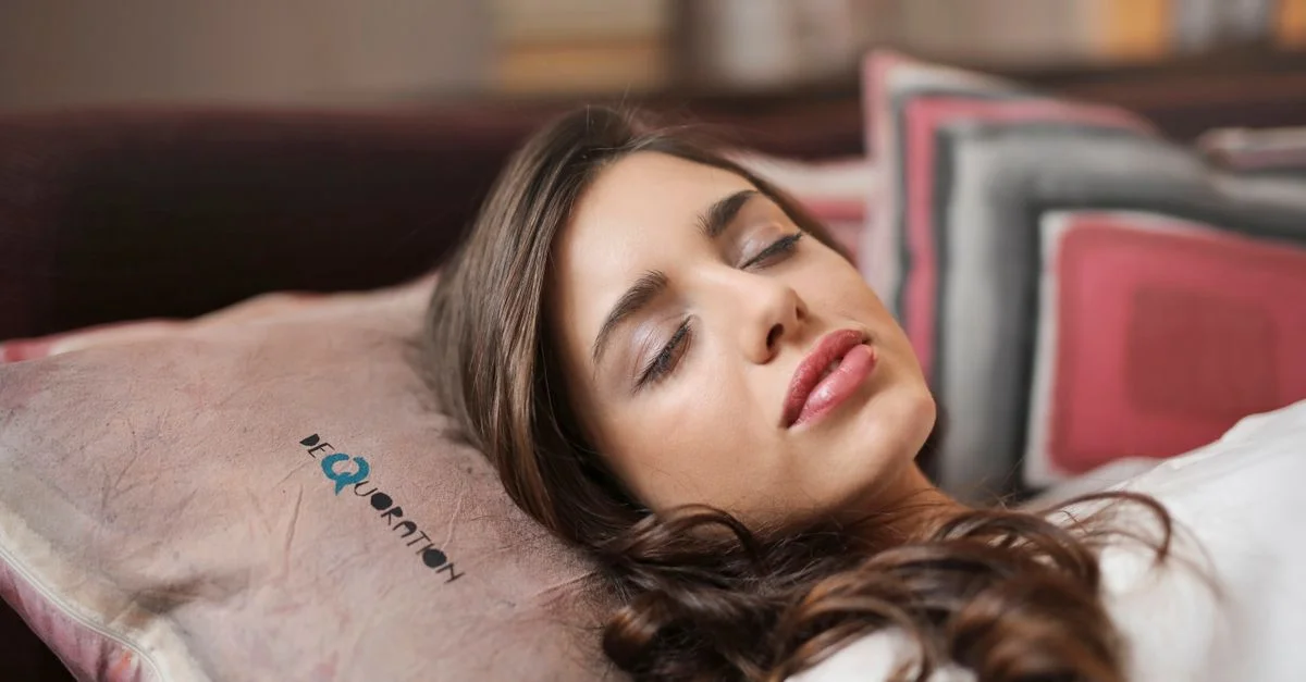 Une femme dormant paisiblement à l'intérieur sur un oreiller, dégagée de confort et de relaxation.